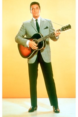 Elvis Presley plays guitar in suit