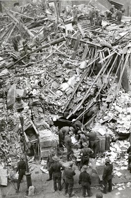, Soldiers, men of the Pionser Corps with pickaxes and shovels, police and civilian rescue squads, after working all night were still searching for men and girls trapped in a block of London Offices, which was bombed during a daylight raid. View showing r
