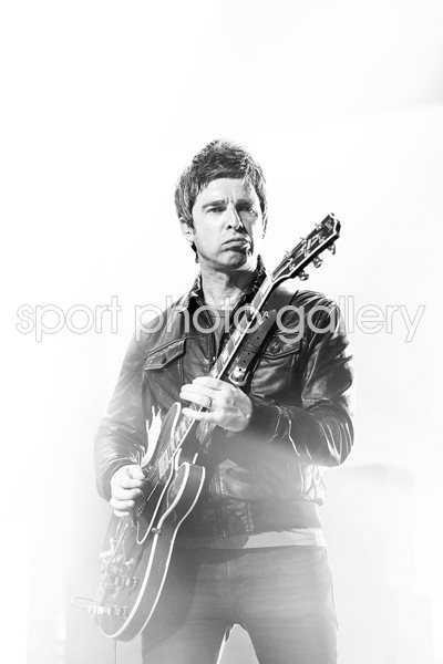 Noel Gallagher plays guitar on stage