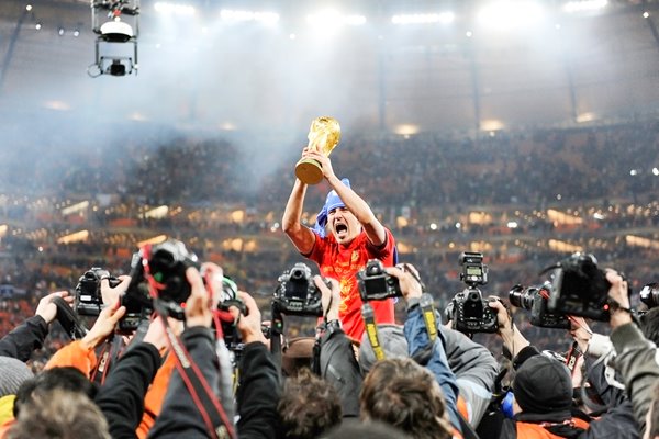 David Villa with the trophy surrounded by paparazzi 