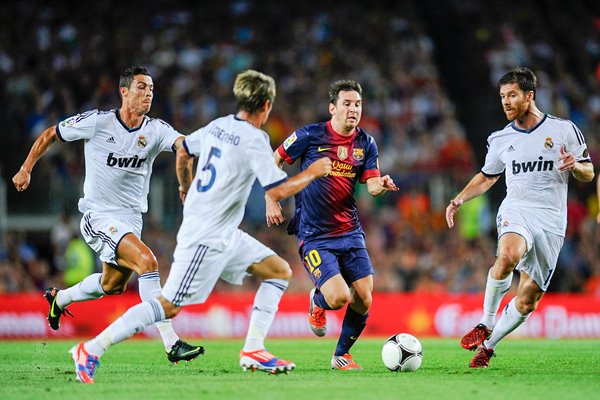 Leo Messi of Barcelona duels for the ball v Real 