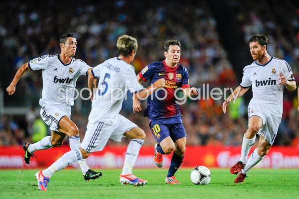 Leo Messi of Barcelona duels for the ball v Real 