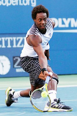 Gael Monfils hits a return v Djokovic