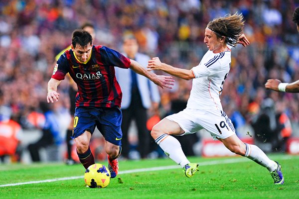 Lionel Messi duels for the ball with Luka Modric