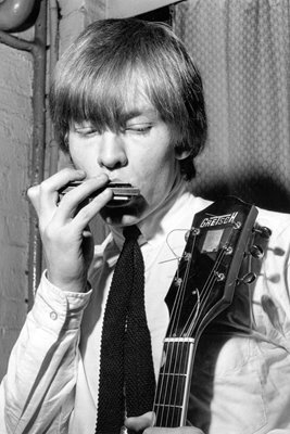 Brian Jones of Rolling Stones playing a harmonica