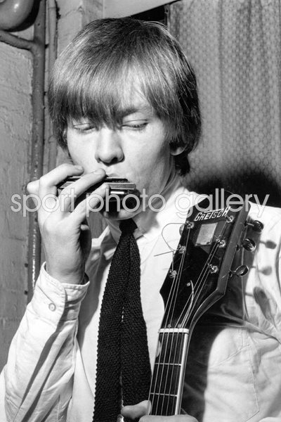 Brian Jones of Rolling Stones playing a harmonica