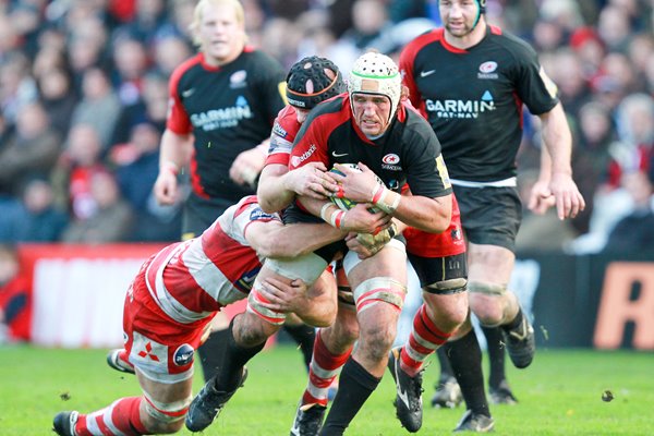 Jacques Burger of Saracens is tackled by Brett Deacon of Gloucester